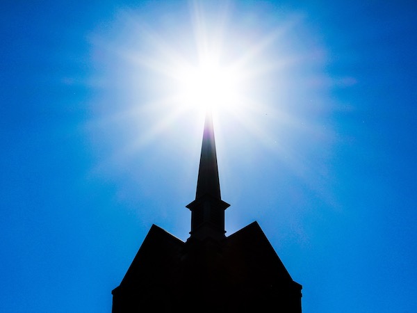 bright-burst-of-sun-rays-atop-a-silhouetted-church-2021-09-04-01-50-22-utc